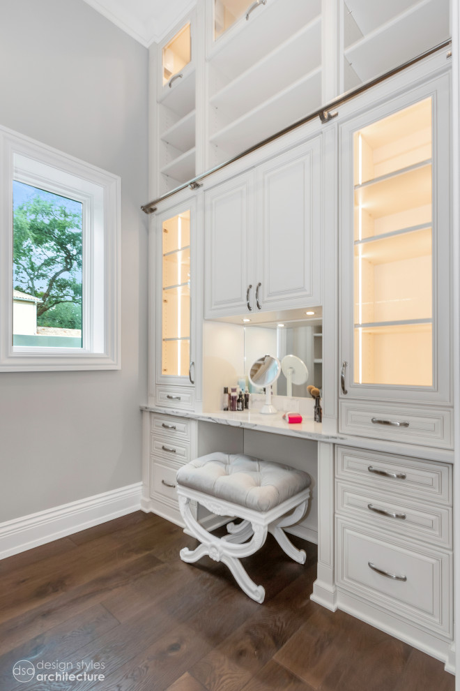 Inspiration for a large traditional gender-neutral dressing room in Tampa with beaded inset cabinets, white cabinets, dark hardwood floors and brown floor.