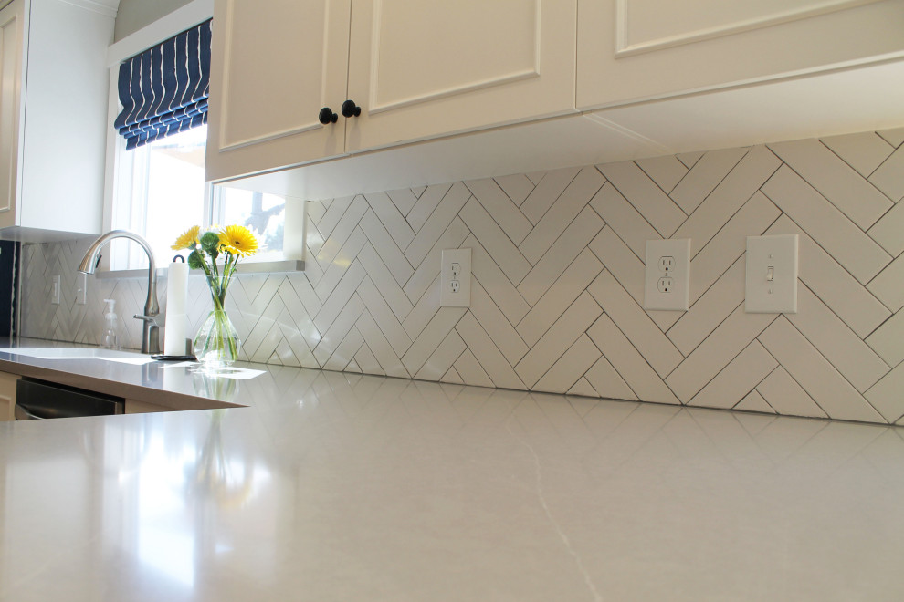 Inspiration for a mid-sized transitional u-shaped medium tone wood floor eat-in kitchen remodel in Seattle with an undermount sink, shaker cabinets, white cabinets, quartz countertops, white backsplash, ceramic backsplash, stainless steel appliances, a peninsula and gray countertops