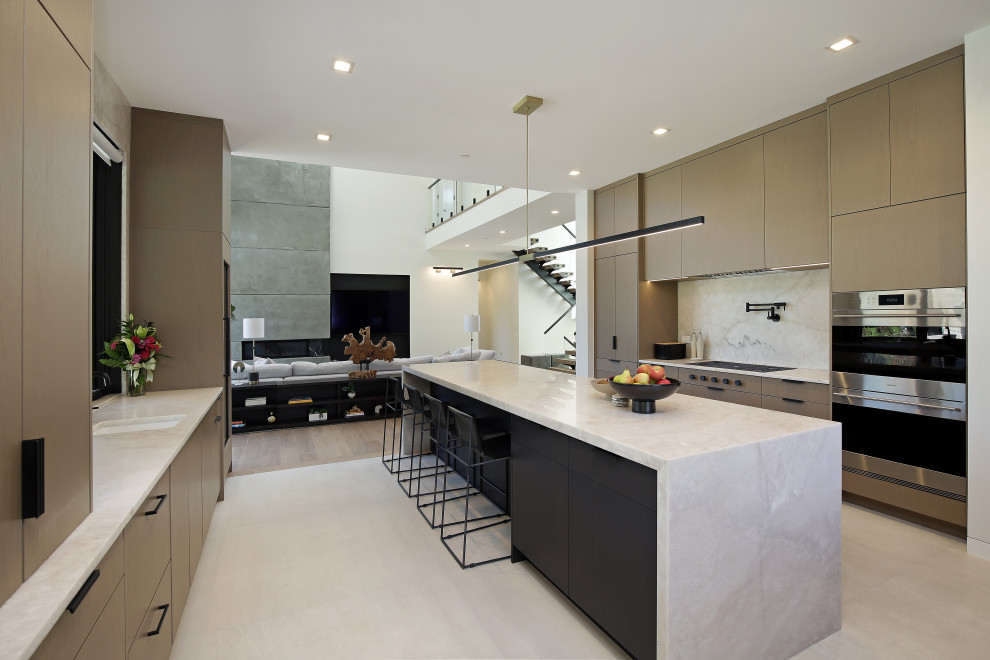 Diseño de cocina minimalista abierta con armarios con paneles lisos, electrodomésticos con paneles, una isla y encimeras blancas