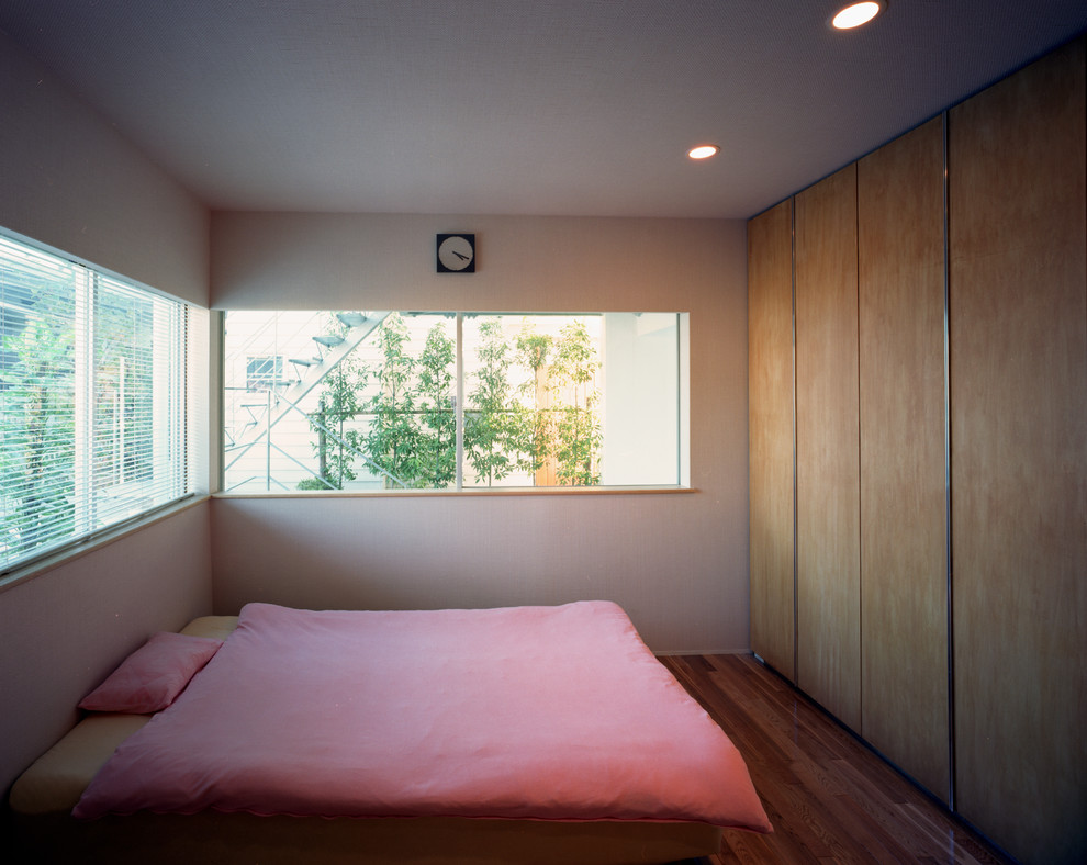 Mittelgroßes Modernes Hauptschlafzimmer ohne Kamin mit weißer Wandfarbe, braunem Holzboden und braunem Boden in Tokio