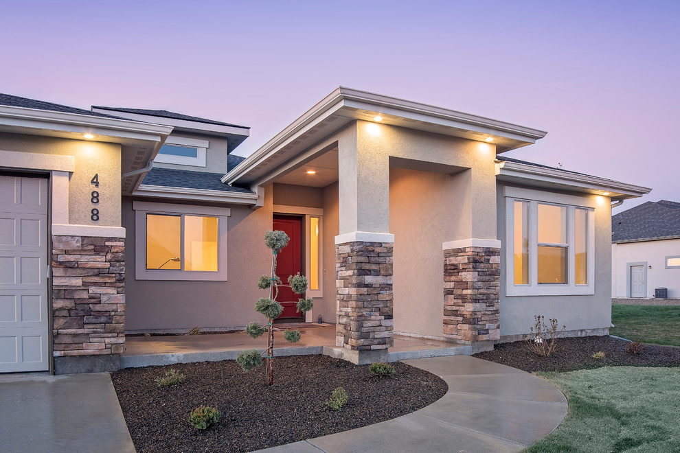 Photo of a mid-sized transitional one-storey stucco grey exterior in Boise with a hip roof.