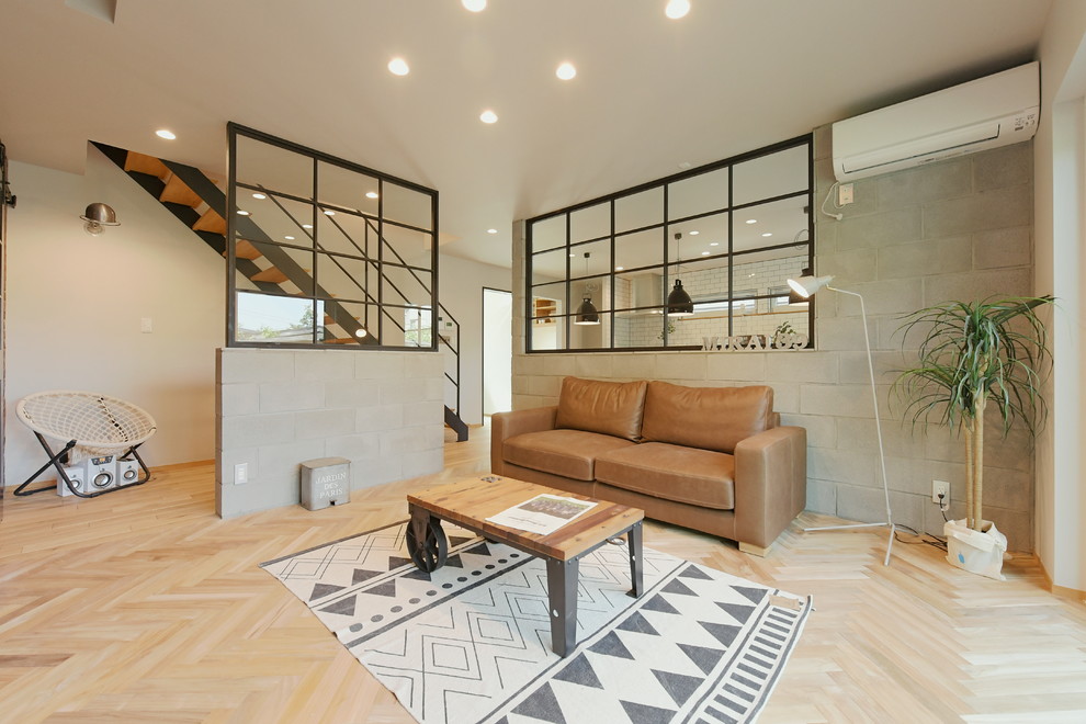 This is an example of an industrial living room in Other with white walls, light hardwood floors and beige floor.