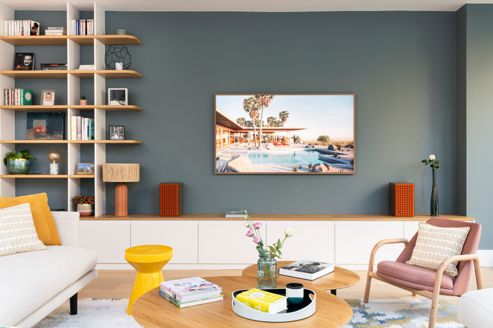Photo of a large contemporary formal open concept living room in London with blue walls, light hardwood floors, a wall-mounted tv and beige floor.