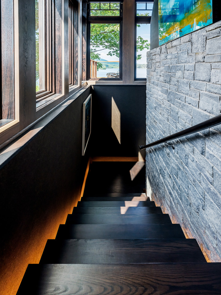 Custom staircase disappears behind the central fireplace, featuring LED lighting - Elizabeth Pedinotti Haynes