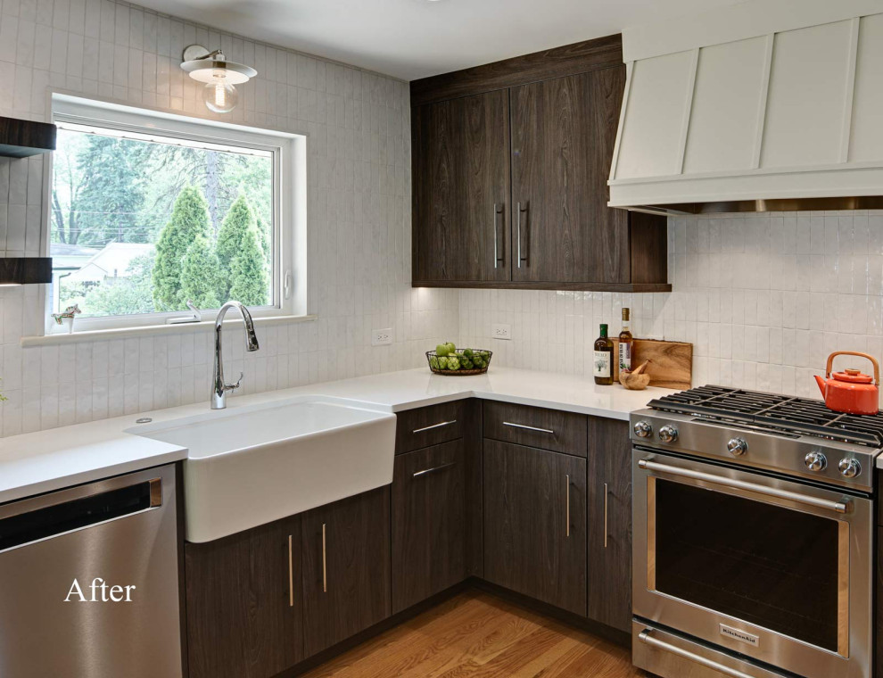 Small retro l-shaped kitchen pantry in Chicago with a belfast sink, flat-panel cabinets, dark wood cabinets, engineered stone countertops, white splashback, ceramic splashback, stainless steel appliances, light hardwood flooring, brown floors and white worktops.