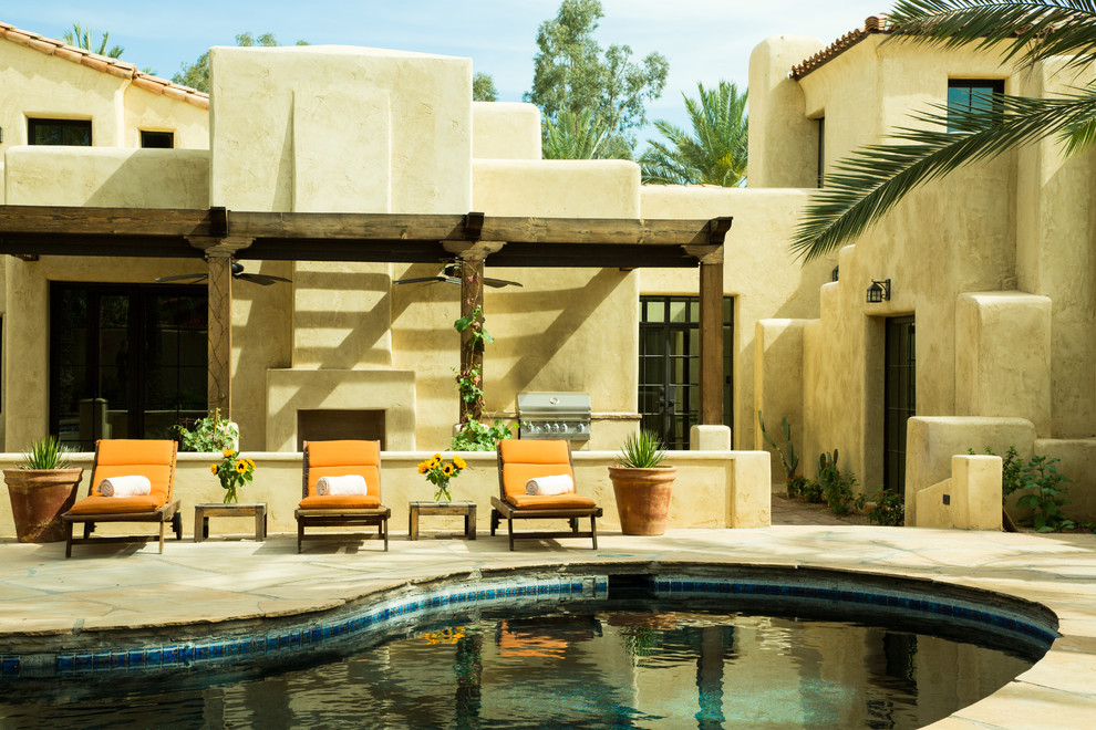 Design ideas for an expansive two-storey adobe beige house exterior in Phoenix with a flat roof.