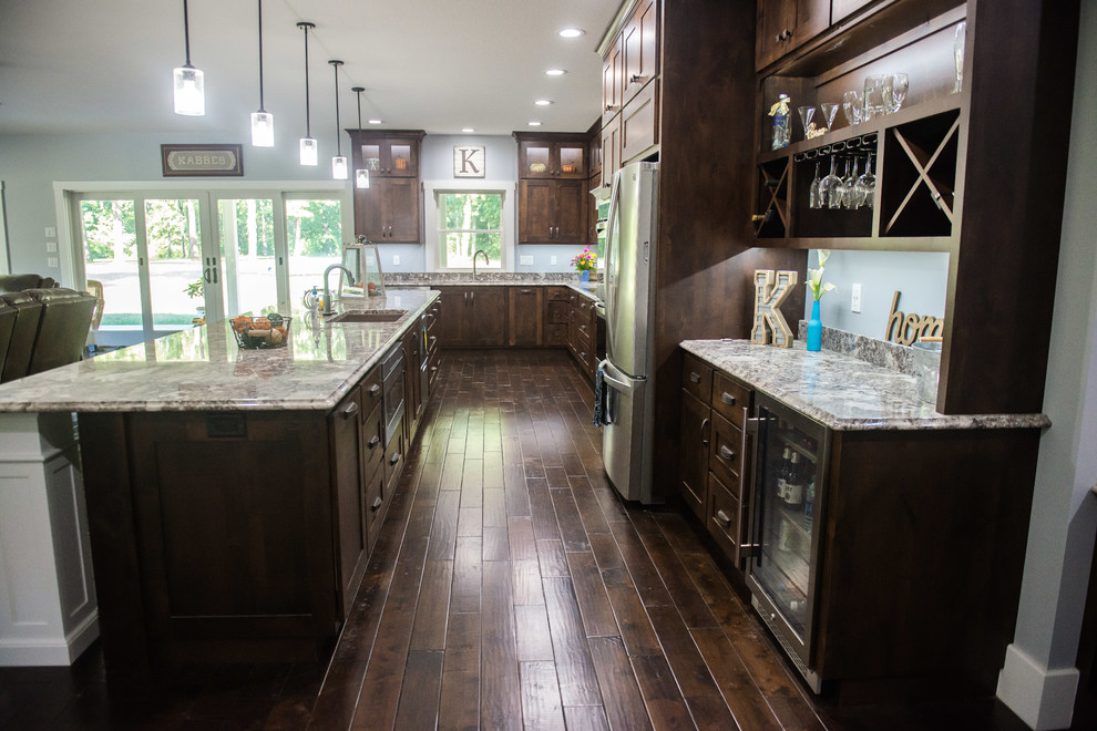 Open concept kitchen - transitional l-shaped open concept kitchen idea with an undermount sink, shaker cabinets, dark wood cabinets, granite countertops, stainless steel appliances, an island and multicolored countertops