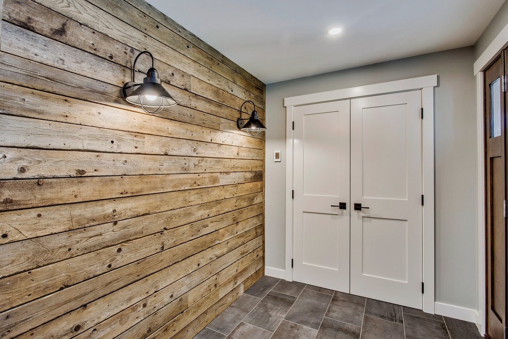 Inspiration for a large country front door in Calgary with grey walls, porcelain floors, a single front door, a medium wood front door and grey floor.