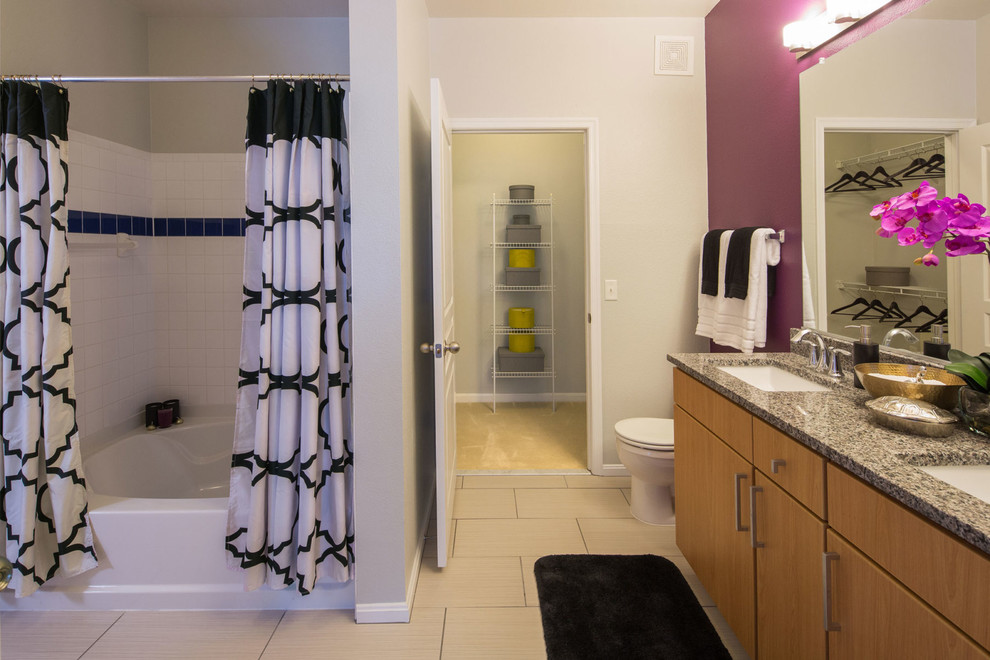 This is an example of an eclectic master bathroom in DC Metro with purple walls and a shower curtain.