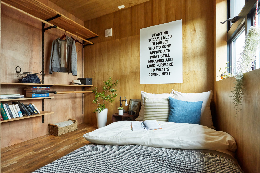 Design ideas for an industrial bedroom in Other with brown walls, medium hardwood floors, brown floor, wood and wood walls.