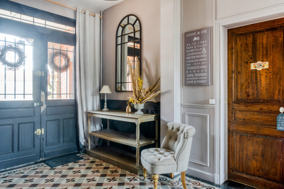 This is an example of a mid-sized transitional front door in Paris with pink walls, ceramic floors, a double front door, a black front door and multi-coloured floor.