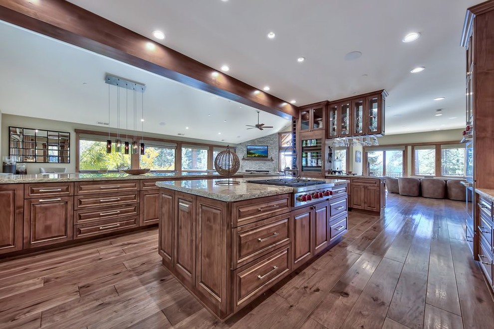 Example of a huge transitional u-shaped medium tone wood floor and multicolored floor open concept kitchen design with a double-bowl sink, raised-panel cabinets, medium tone wood cabinets, granite countertops, multicolored backsplash, stone slab backsplash, paneled appliances, an island and multicolored countertops