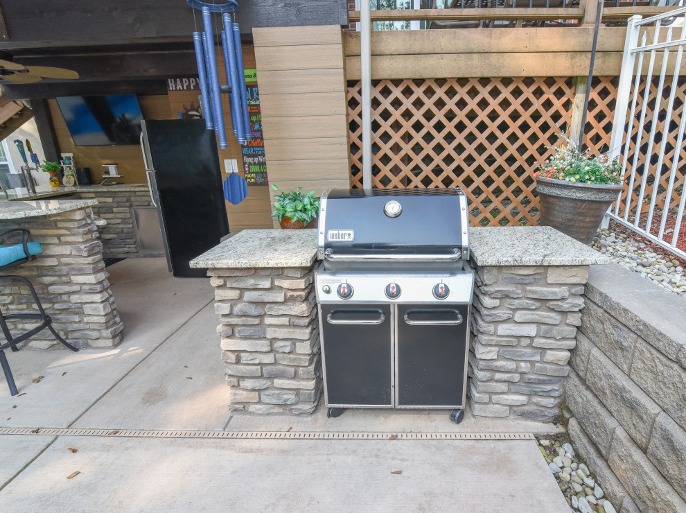 Inspiration for a small country backyard patio in Cincinnati with an outdoor kitchen, concrete slab and a roof extension.