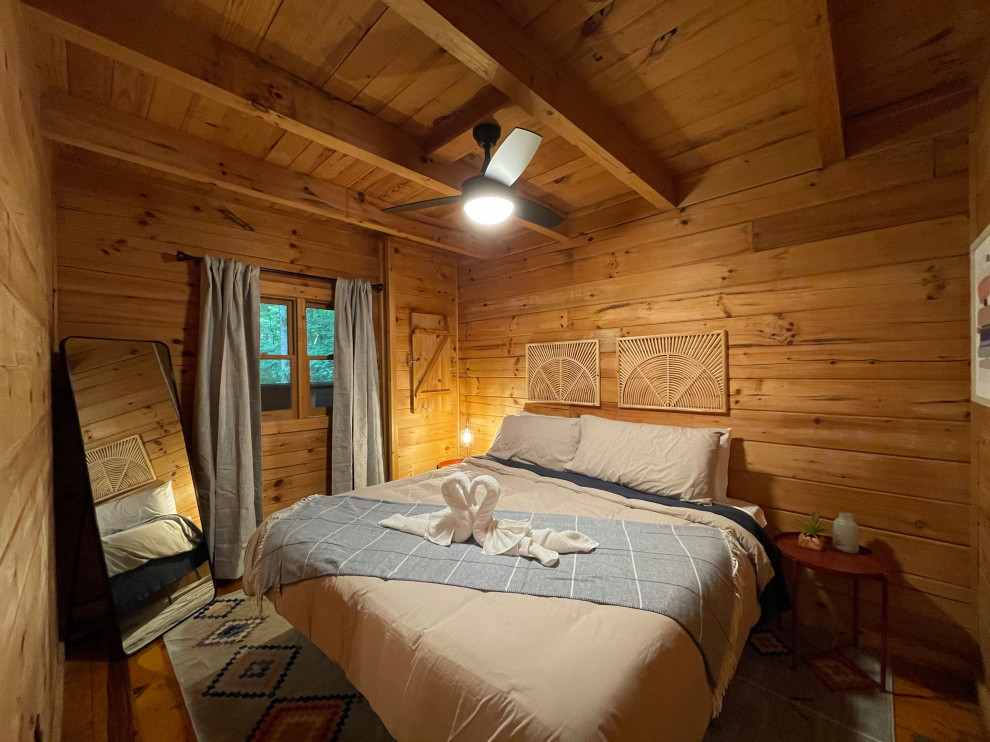 Idée de décoration pour une petite chambre parentale chalet avec un sol en bois brun et aucune cheminée.