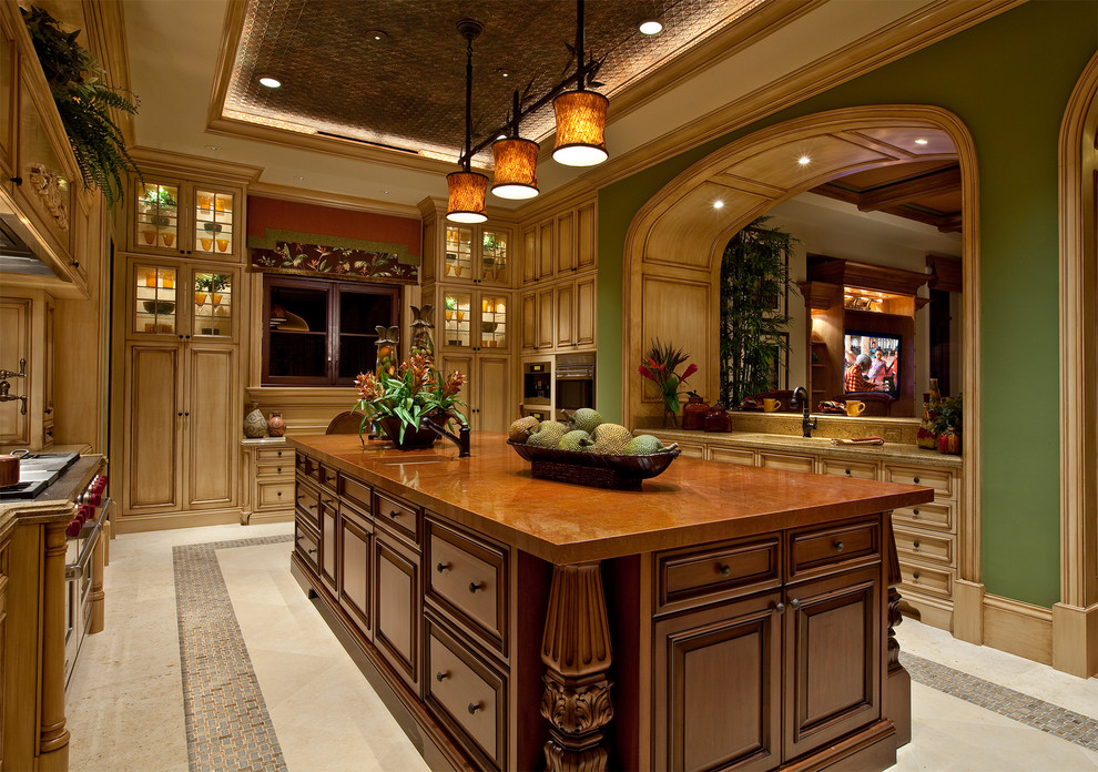 Photo of a mediterranean kitchen in Miami with raised-panel cabinets and light wood cabinets.