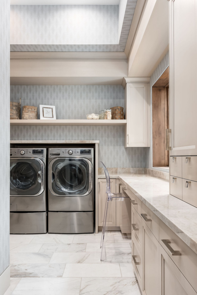 Photo of a modern u-shaped laundry room in Salt Lake City with a drop-in sink, porcelain floors, a side-by-side washer and dryer, white floor, beige benchtop and wallpaper.