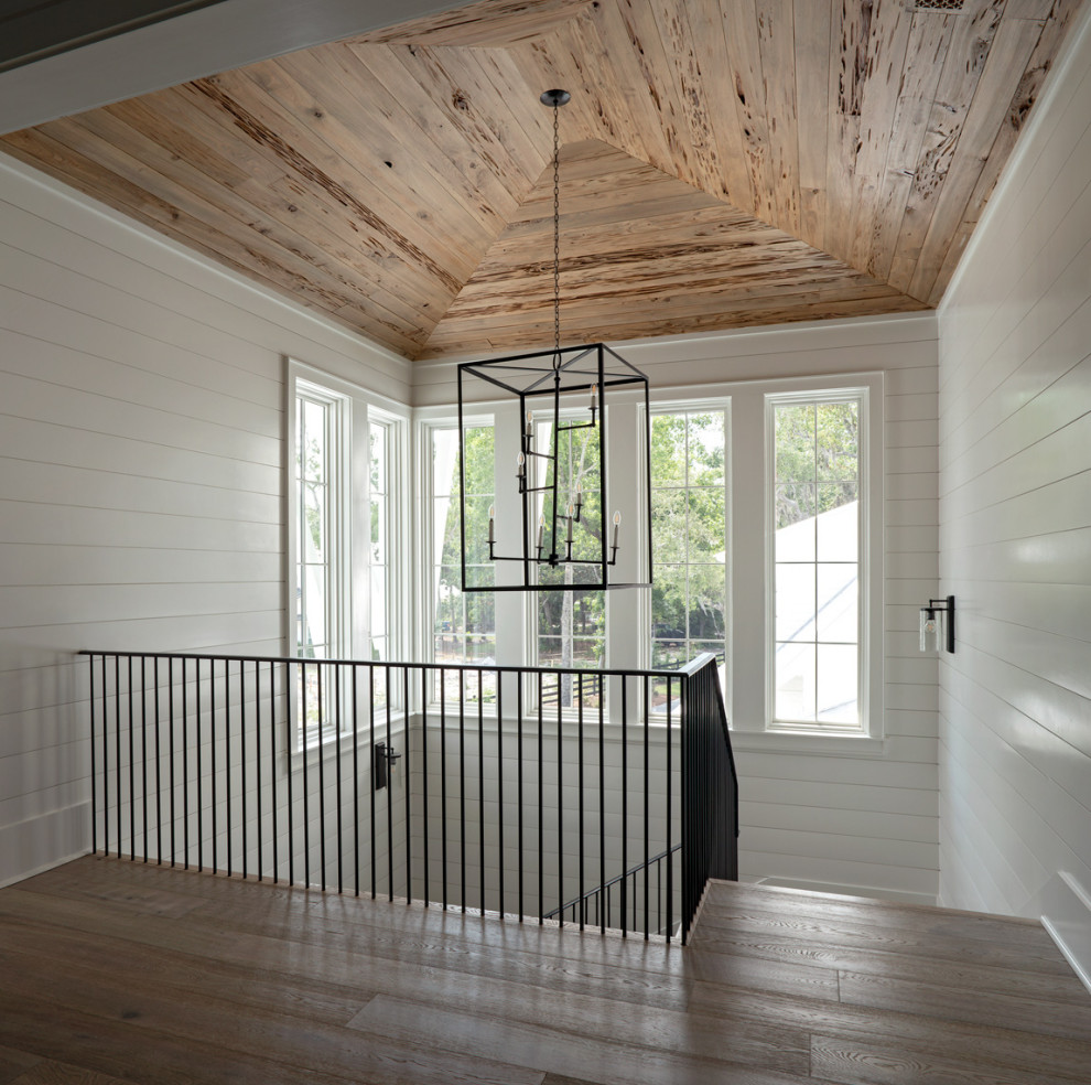 Inspiration for a large traditional wood u-shaped metal railing staircase in Other with wood risers and tongue and groove walls.