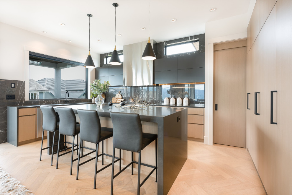 Inspiration for a large contemporary light wood floor eat-in kitchen remodel in Vancouver with an undermount sink, flat-panel cabinets, light wood cabinets, quartz countertops, black backsplash, marble backsplash, stainless steel appliances, an island and gray countertops