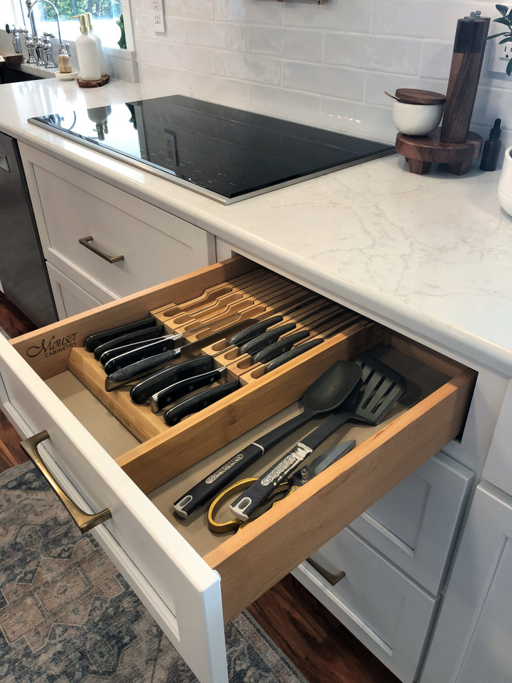 Example of a mid-sized transitional l-shaped medium tone wood floor and brown floor kitchen pantry design with an undermount sink, flat-panel cabinets, blue cabinets, quartz countertops, white backsplash, subway tile backsplash, stainless steel appliances, an island and gray countertops