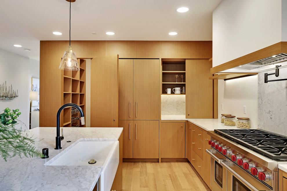 This is an example of a large scandinavian l-shaped open plan kitchen in Seattle with a farmhouse sink, flat-panel cabinets, medium wood cabinets, stainless steel appliances, medium hardwood floors, with island, brown floor and multi-coloured benchtop.