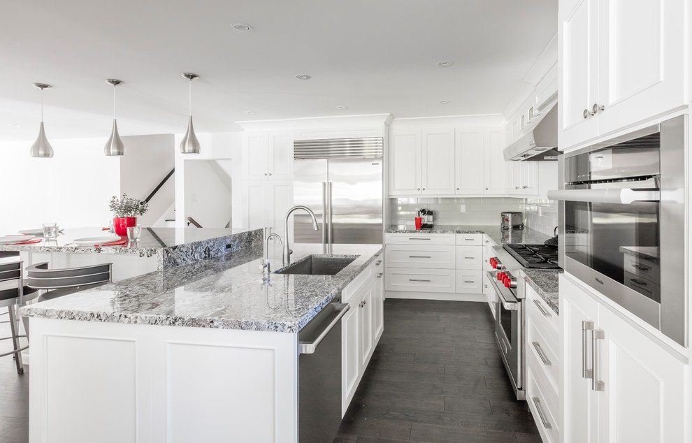 Mid-sized transitional brown floor kitchen photo in Toronto with white cabinets, stainless steel appliances and an island