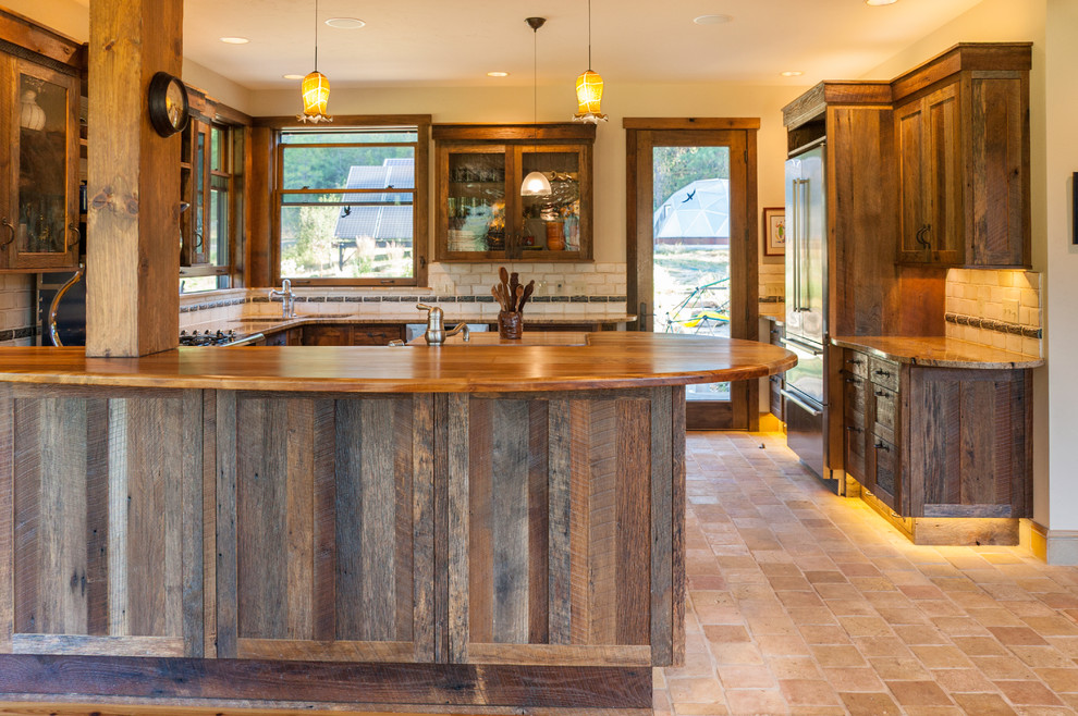 Large mountain style u-shaped cement tile floor and beige floor open concept kitchen photo in Seattle with recessed-panel cabinets, granite countertops, beige backsplash, ceramic backsplash, stainless steel appliances, an island, an undermount sink and dark wood cabinets