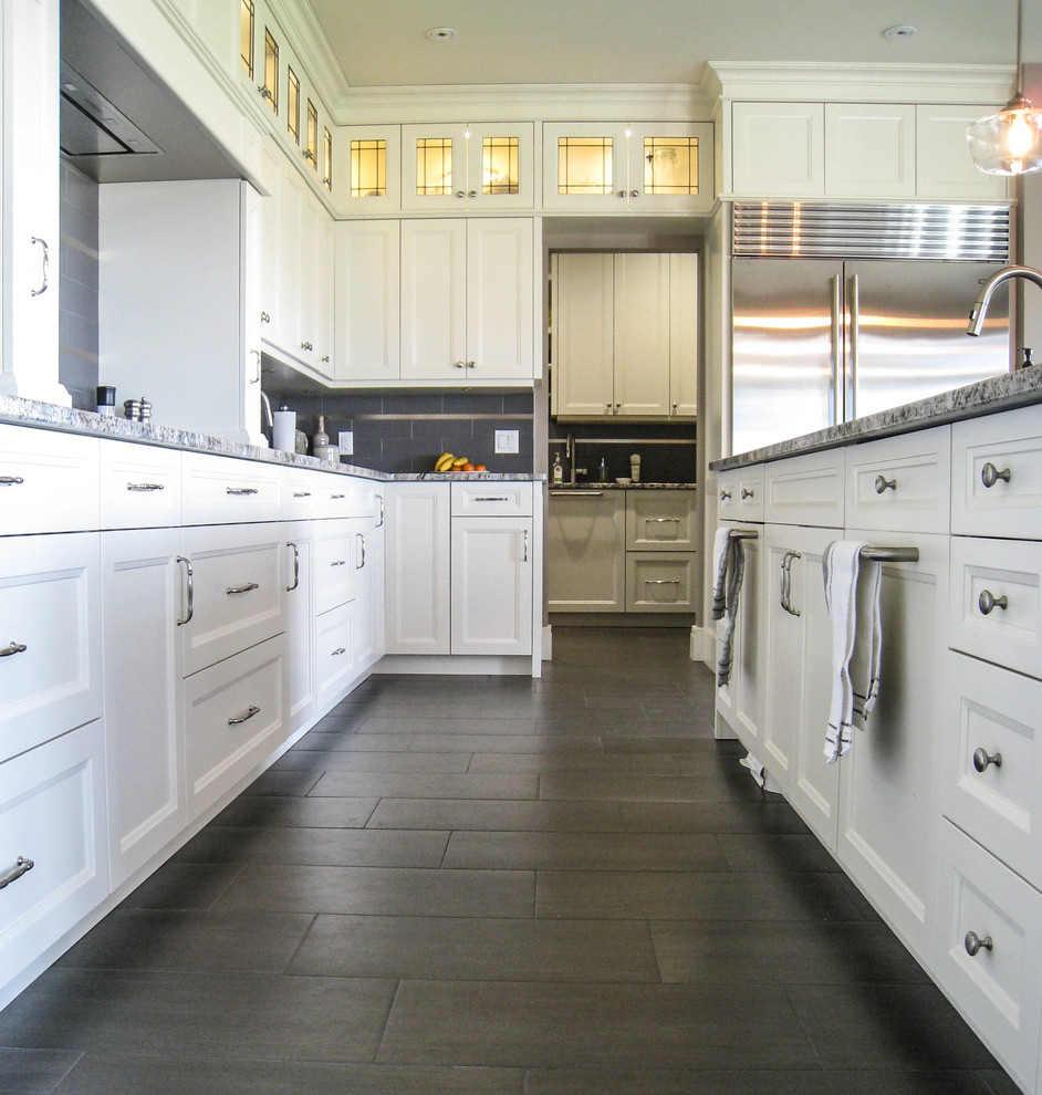 Transitional l-shaped gray floor eat-in kitchen photo in Toronto with an undermount sink, white cabinets, granite countertops, gray backsplash, stainless steel appliances and an island