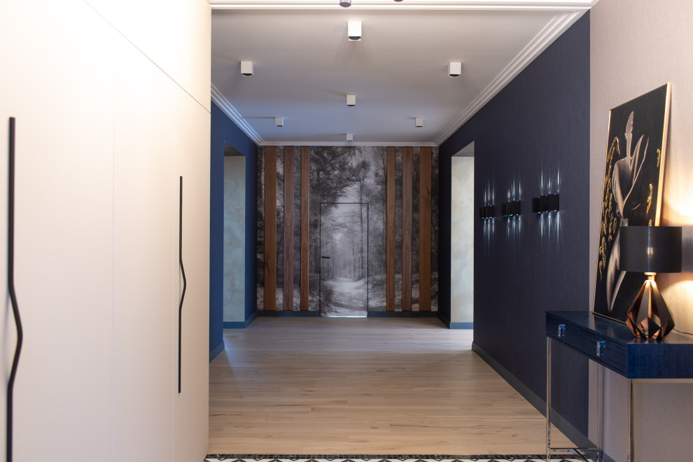 Стильный дизайн: фойе среднего размера: освещение в современном стиле с синими стенами, полом из керамической плитки, одностворчатой входной дверью, серой входной дверью и обоями на стенах - последний тренд
