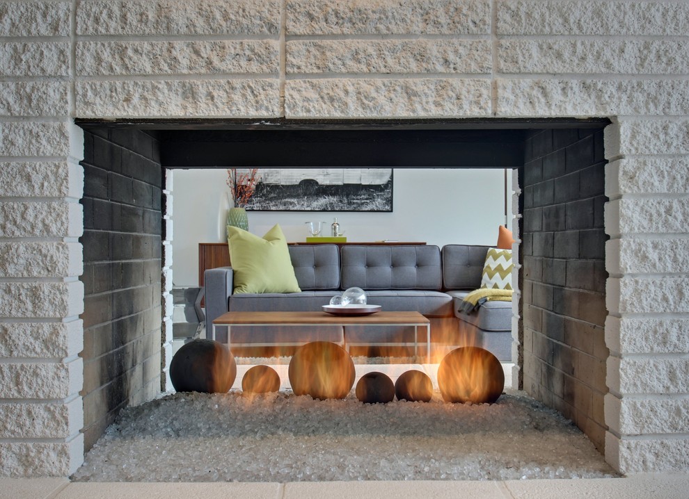 Mid-sized contemporary open concept living room in Los Angeles with white walls, concrete floors, a two-sided fireplace, a brick fireplace surround and a wall-mounted tv.
