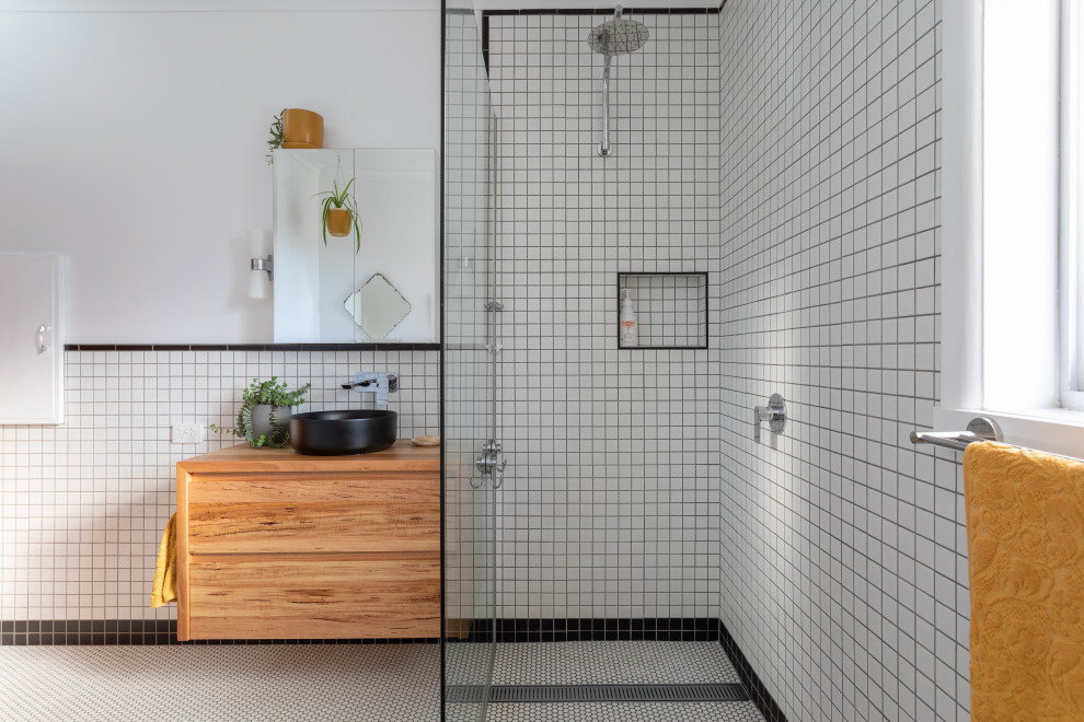 Retro inredning av ett litet en-suite badrum, med luckor med infälld panel, skåp i mellenmörkt trä, ett hörnbadkar, våtrum, svart och vit kakel, keramikplattor, vita väggar, klinkergolv i keramik, träbänkskiva, vitt golv och med dusch som är öppen