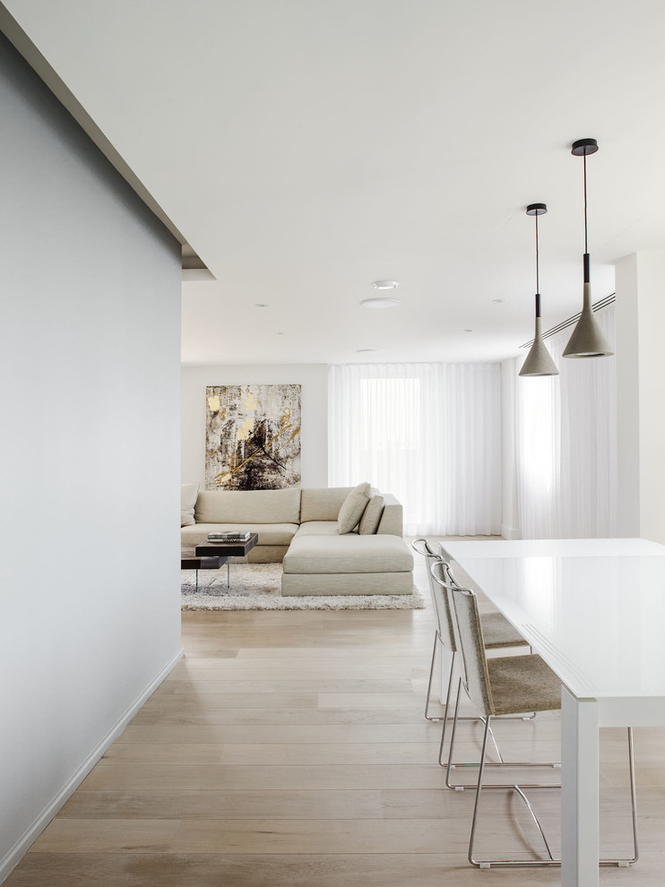 Inspiration for a large contemporary open plan dining in London with grey walls and light hardwood floors.