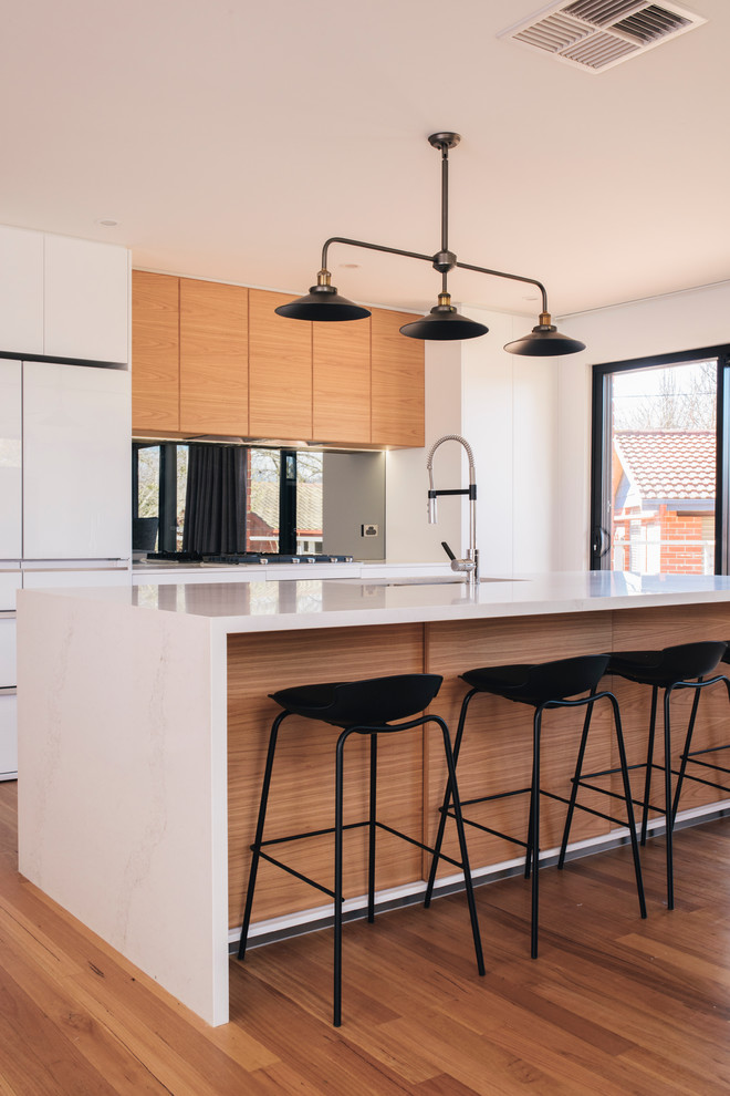 Design ideas for a contemporary galley eat-in kitchen in Canberra - Queanbeyan with an undermount sink, marble benchtops, mirror splashback, medium hardwood floors, with island, flat-panel cabinets and light wood cabinets.