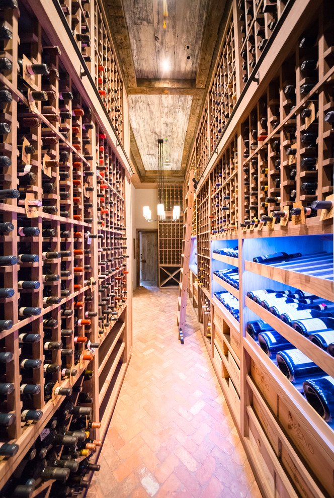 Inspiration for an expansive country wine cellar in New York with brick floors, storage racks and red floor.