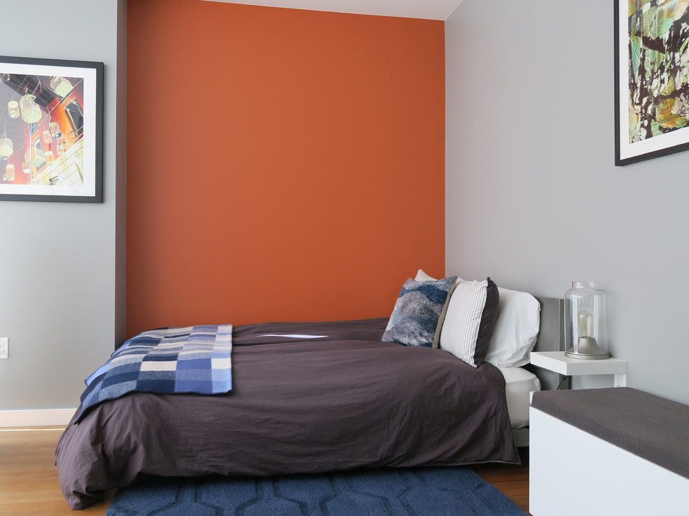 サンフランシスコにある小さなコンテンポラリースタイルのおしゃれな客用寝室 (オレンジの壁、無垢フローリング、暖炉なし、茶色い床) のレイアウト