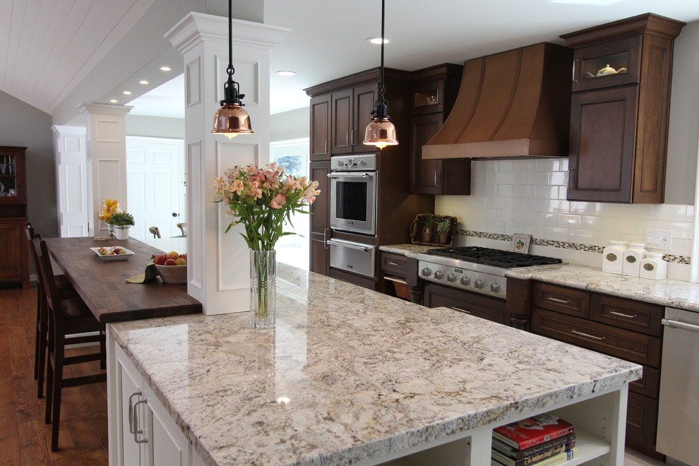 Eat-in kitchen - mid-sized rustic l-shaped porcelain tile eat-in kitchen idea in San Francisco with a farmhouse sink, recessed-panel cabinets, dark wood cabinets, wood countertops, white backsplash, subway tile backsplash, paneled appliances and an island