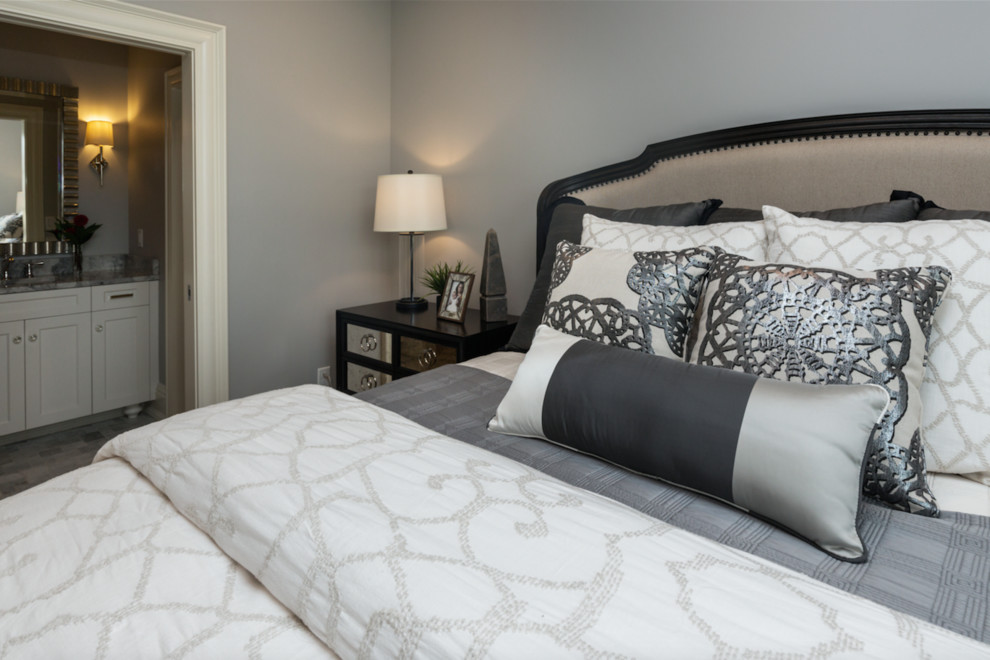 Large transitional master medium tone wood floor bedroom photo with gray walls and no fireplace