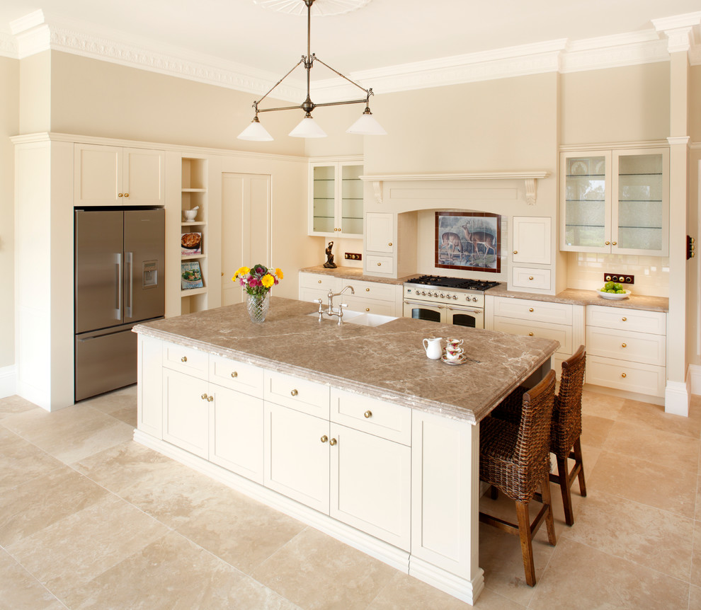 Photo of a mid-sized traditional galley eat-in kitchen in Sydney with glass-front cabinets, a farmhouse sink, white appliances, travertine floors, marble benchtops and with island.