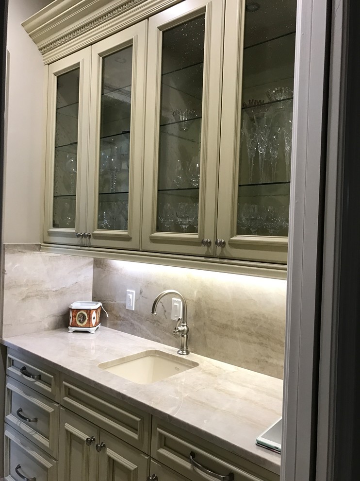 Inspiration for a mid-sized mediterranean galley wet bar in Miami with glass-front cabinets, light wood cabinets, marble benchtops, beige splashback, stone slab splashback and marble floors.