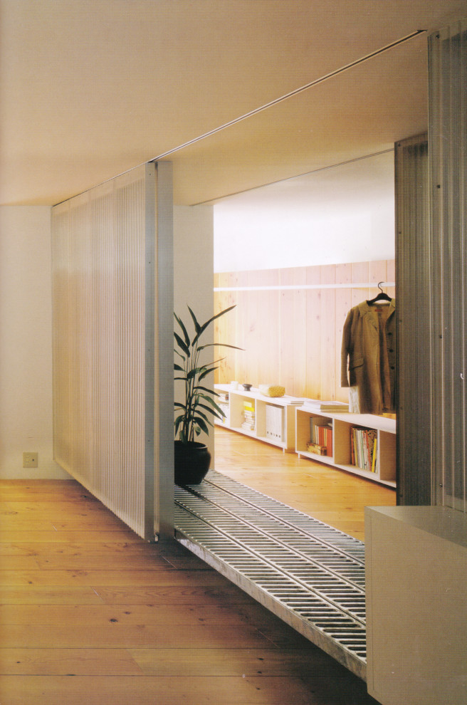 Idee per un piccolo ingresso o corridoio minimalista con pavimento grigio e pannellatura