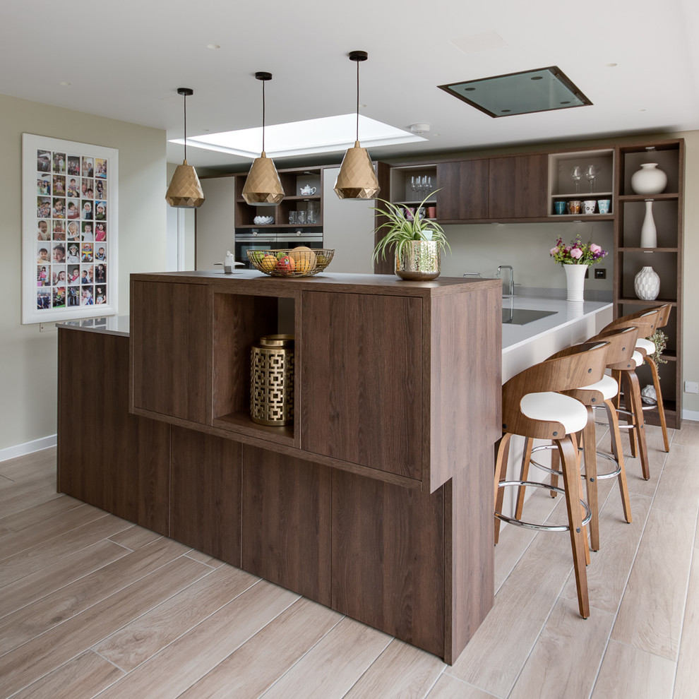 Large contemporary u-shaped eat-in kitchen in Buckinghamshire with an undermount sink, flat-panel cabinets, beige cabinets, quartzite benchtops, panelled appliances and ceramic floors.