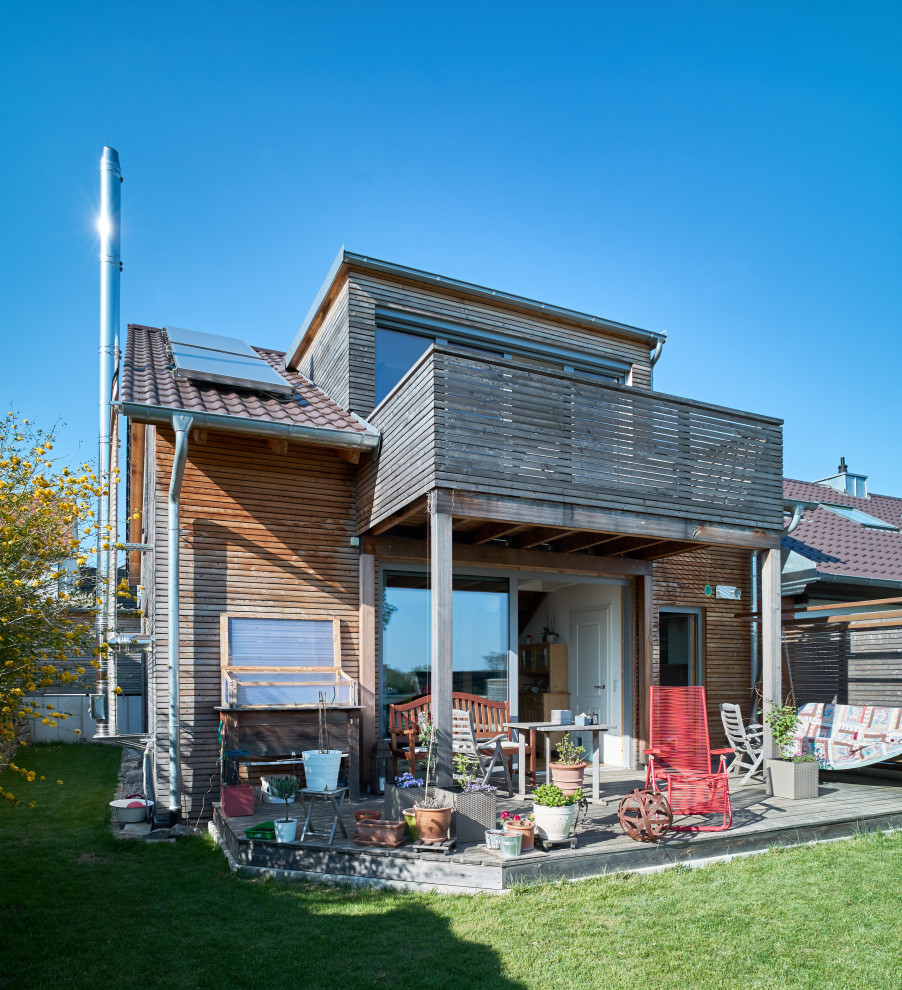 Kleines Country Haus mit Satteldach, braunem Dach, Verschalung und Dachgaube in Sonstige