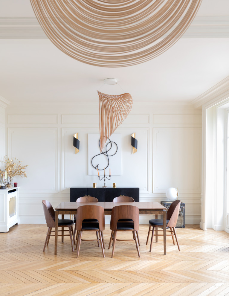 Ejemplo de comedor actual con paredes blancas, suelo de madera clara, suelo beige y panelado