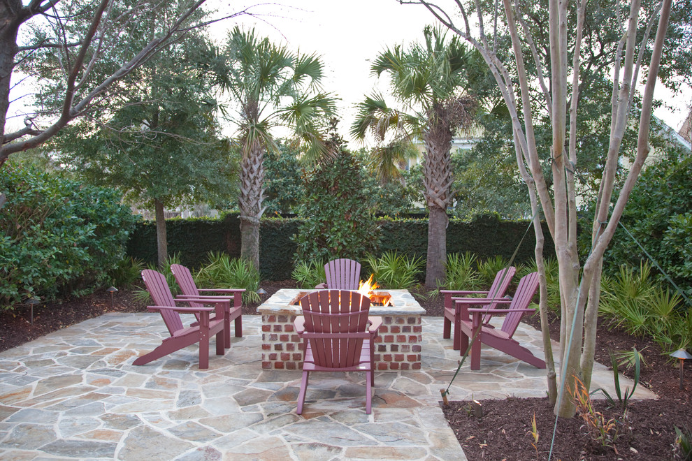 This is an example of a contemporary backyard patio in Charleston with a fire feature and natural stone pavers.