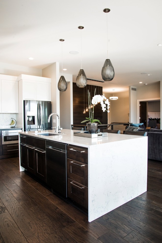 Enclosed kitchen - large transitional l-shaped dark wood floor enclosed kitchen idea in Orange County with an undermount sink, shaker cabinets, white cabinets, quartz countertops, white backsplash, mosaic tile backsplash, stainless steel appliances and an island