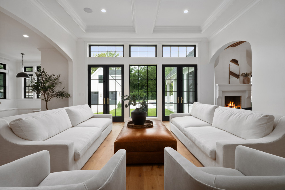 Photo of an expansive country open concept family room in St Louis with white walls, light hardwood floors and recessed.