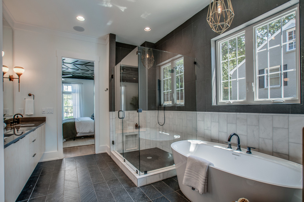 Large contemporary master bathroom in Nashville with flat-panel cabinets, light wood cabinets, a freestanding tub, a corner shower, black and white tile, white walls, an undermount sink, black floor, a hinged shower door and black benchtops.