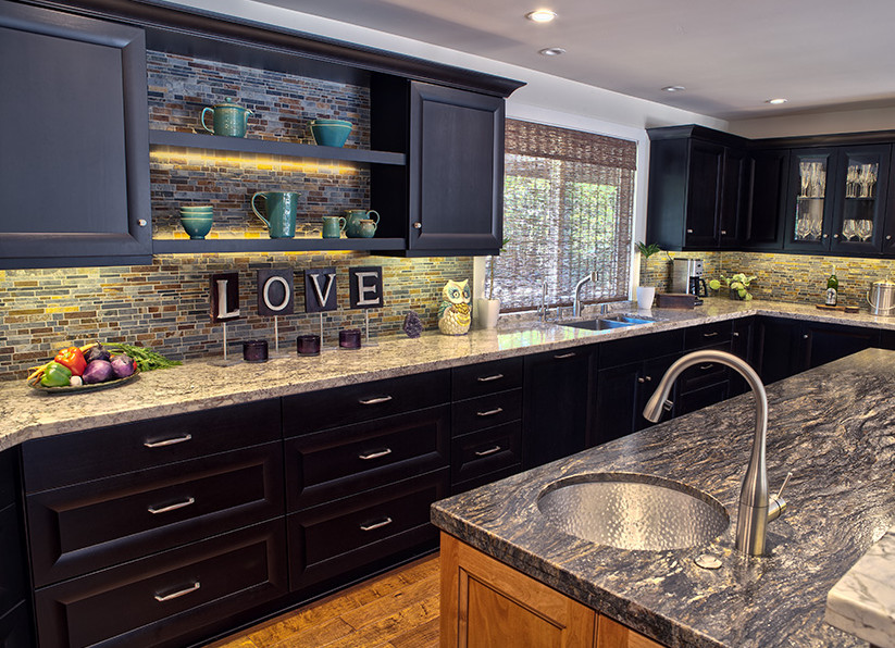 Inspiration for a large transitional u-shaped medium tone wood floor and brown floor eat-in kitchen remodel in Sacramento with a double-bowl sink, recessed-panel cabinets, black cabinets, granite countertops, multicolored backsplash, glass tile backsplash, stainless steel appliances, an island and gray countertops