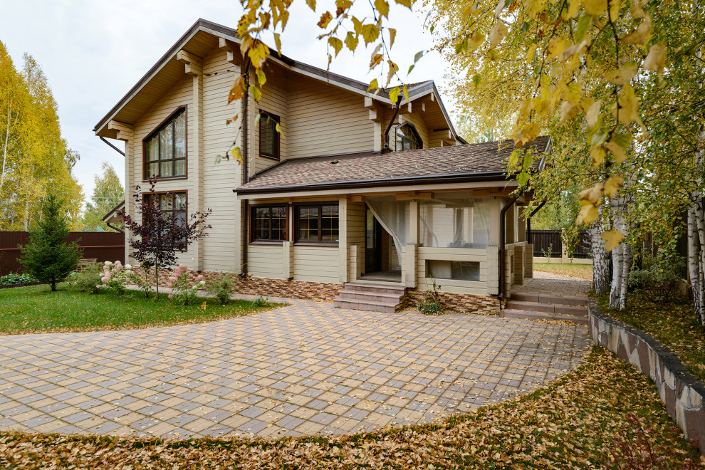 Ejemplo de fachada de casa beige y marrón escandinava de dos plantas con revestimiento de madera y tejado a dos aguas