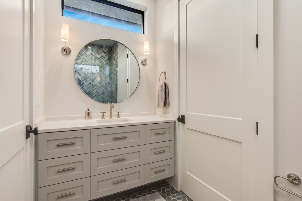 Mid-sized transitional 3/4 bathroom with shaker cabinets, white cabinets, an alcove shower, a one-piece toilet, multi-coloured tile, matchstick tile, white walls, porcelain floors, an integrated sink, engineered quartz benchtops, multi-coloured floor, a hinged shower door and white benchtops.