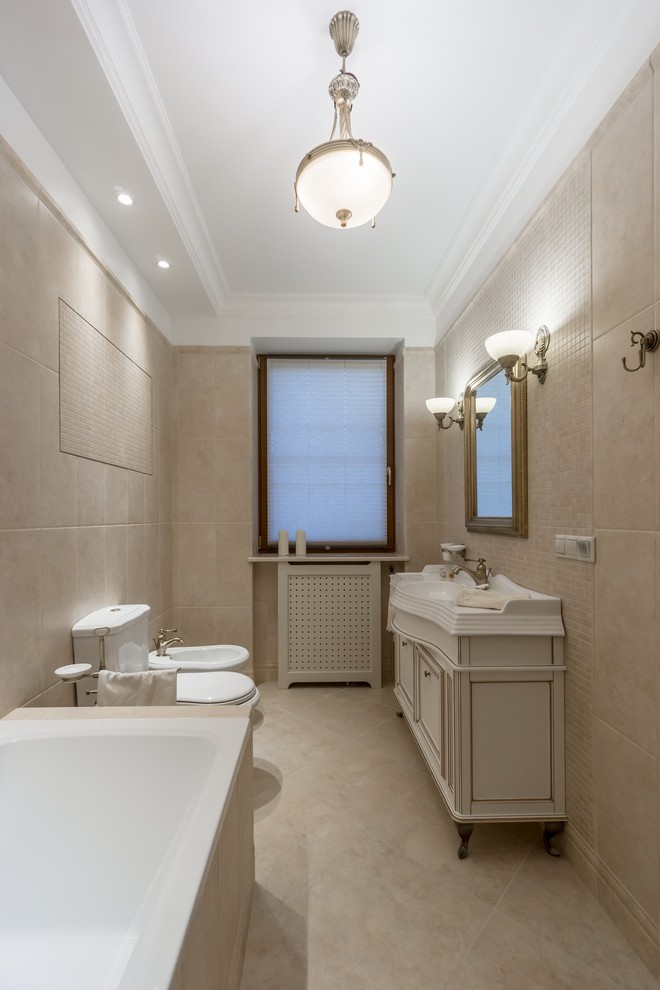 Design ideas for a large traditional master bathroom in Moscow with raised-panel cabinets, distressed cabinets, an undermount tub, a two-piece toilet, beige tile, ceramic tile, beige walls, ceramic floors, an undermount sink, marble benchtops and beige floor.